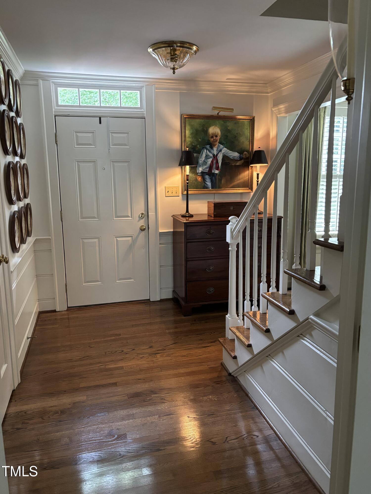 9301 Brookton Court Raleigh, NC 27615 - Photo 6 of 29 a view of a hallway with wooden floor and stairs