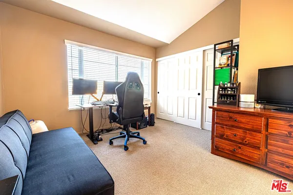 a view of a livingroom with workspace and a window