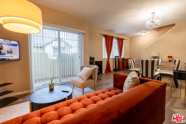 a living room with furniture a lamp and a large window