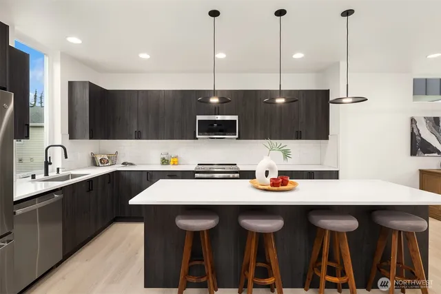 a kitchen with a sink a stove a oven a dining table and chairs