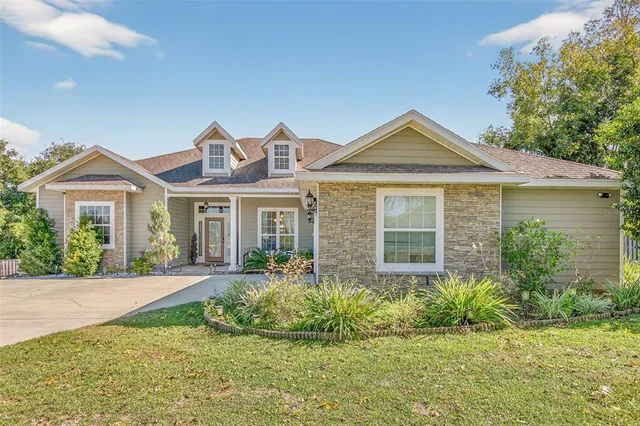 a front view of a house with a yard and potted plants