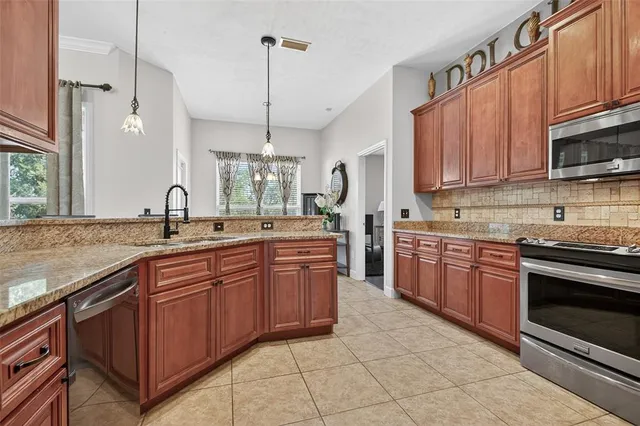 a kitchen with stainless steel appliances granite countertop a sink and stove top oven