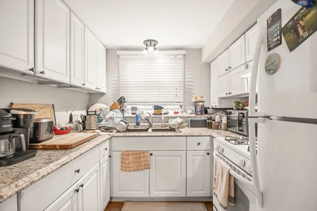 a kitchen with stainless steel appliances granite countertop a sink a stove and cabinets