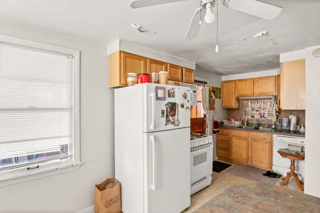 a kitchen with stainless steel appliances a refrigerator a stove a sink cabinets and a dining table