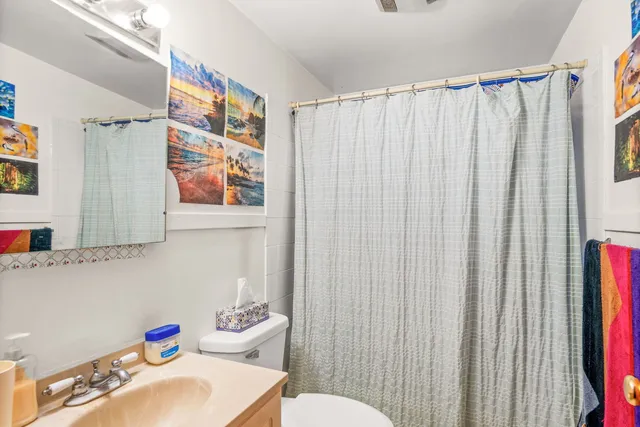 a bathroom with a sink a toilet and shower curtain
