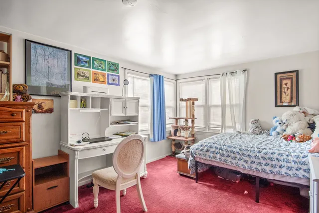 a bedroom with a bed wooden floor and a couch