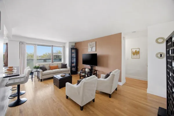 a living room with furniture wooden floor and a flat screen tv