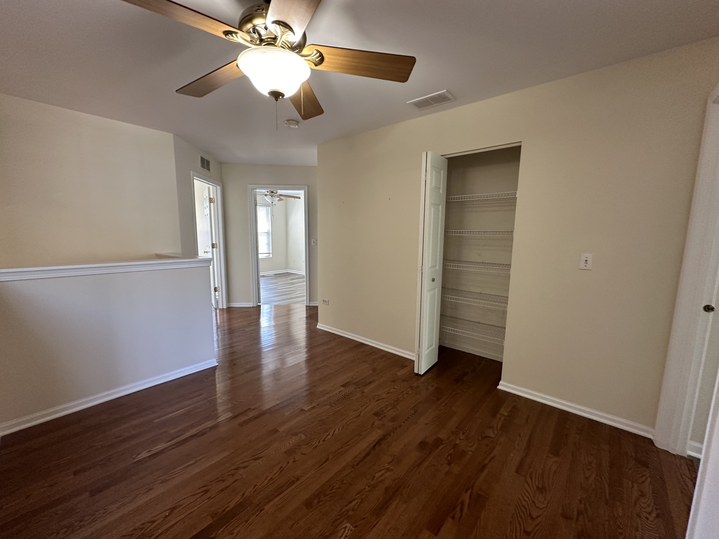 1525 Envee Drive Bolingbrook, IL 60490 - Photo 20 of 30 a view of an empty room with wooden floor and a ceiling fan