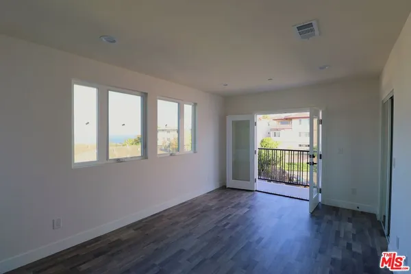 a kitchen with stainless steel appliances granite countertop a refrigerator a sink dishwasher a stove top oven a refrigerator and white cabinets with wooden floor