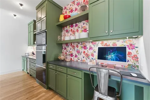 a kitchen with stainless steel appliances cabinets and a wooden floor