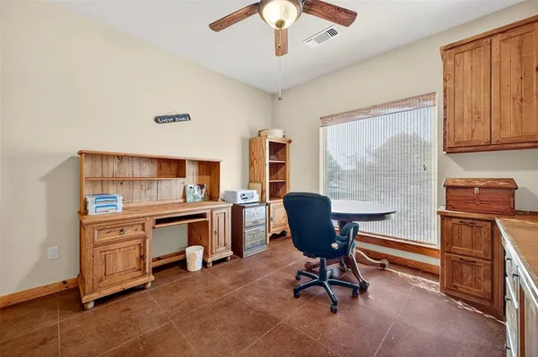 a view of a workspace with furniture and a window