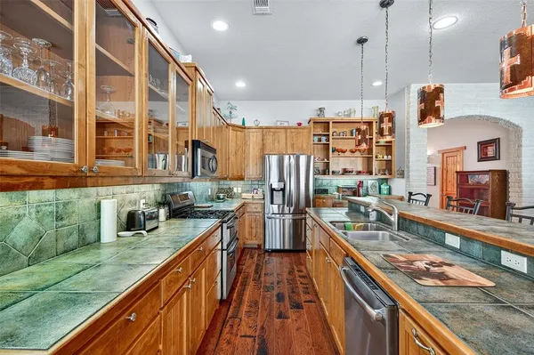 a kitchen with stainless steel appliances granite countertop a stove a sink and a wooden floors