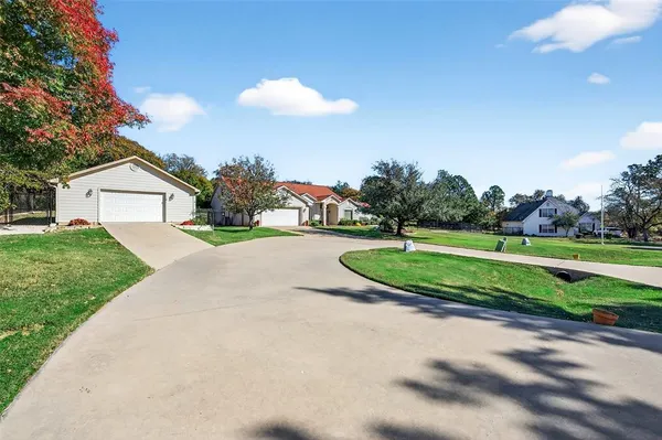 a view of a house with a big yard and potted plants