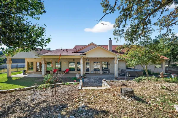 a front view of a house with a yard and tree s
