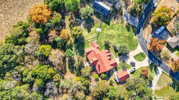 an aerial view of residential house with outdoor space and trees all around