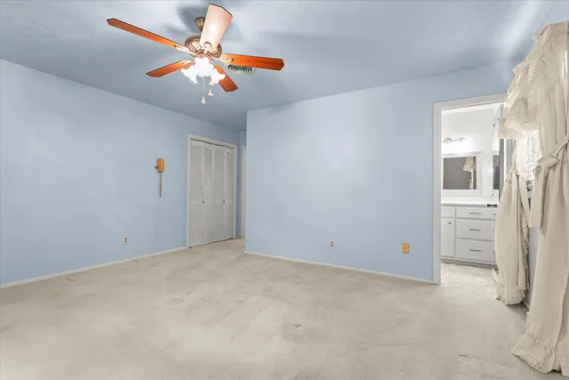 an empty room with chandelier fan