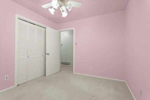 a view of a bedroom with a ceiling fan and a window
