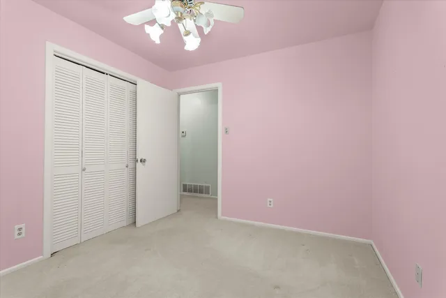 a view of a bedroom with a ceiling fan and a window