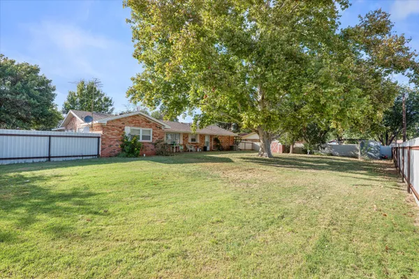 a view of a house with a yard and a tree