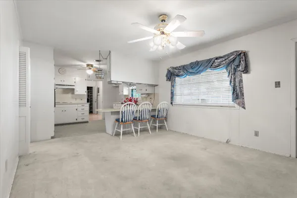 a kitchen with stainless steel appliances kitchen island granite countertop a white table and chairs