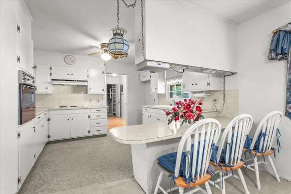 a view of an empty room with a window and a chandelier fan