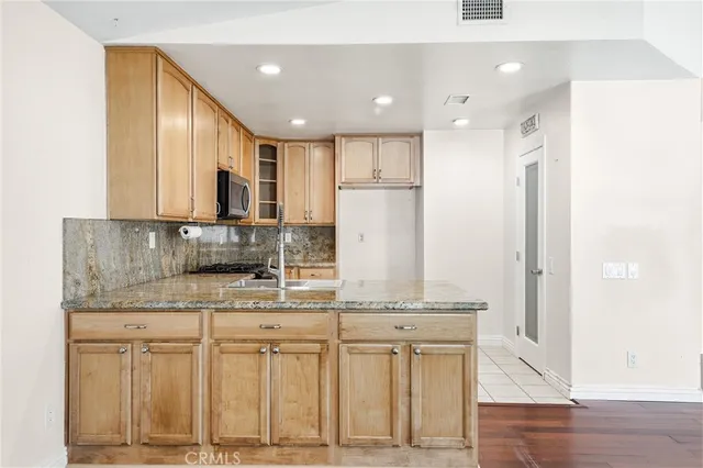 a kitchen with stainless steel appliances granite countertop a sink and a refrigerator