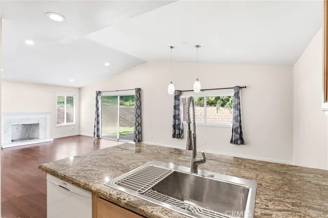 a kitchen with a sink granite counter tops and a window