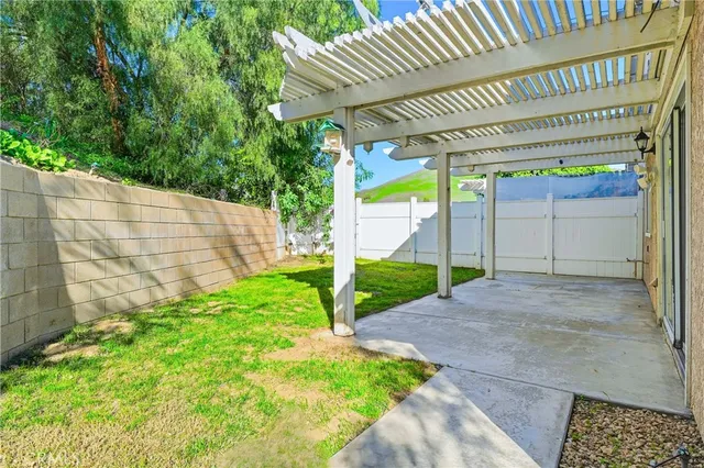 a view of a house with a small yard and wooden fence
