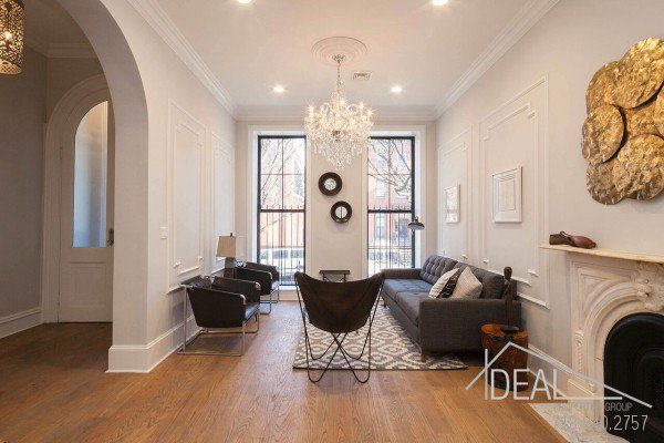 a living room with furniture a fireplace and a chandelier