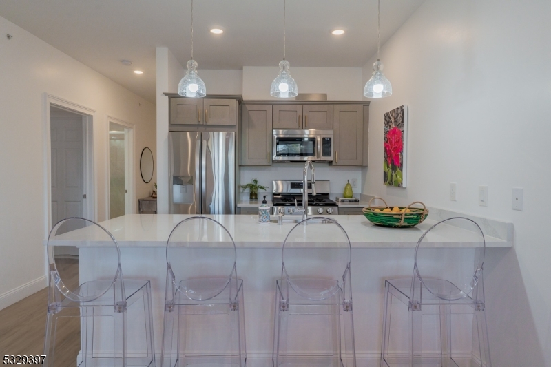 1026 Stuyvesant Avenue, Unit 307 Union, NJ 07083 - Photo 6 of 11 a room with stainless steel appliances kitchen island granite countertop furniture and a refrigerator