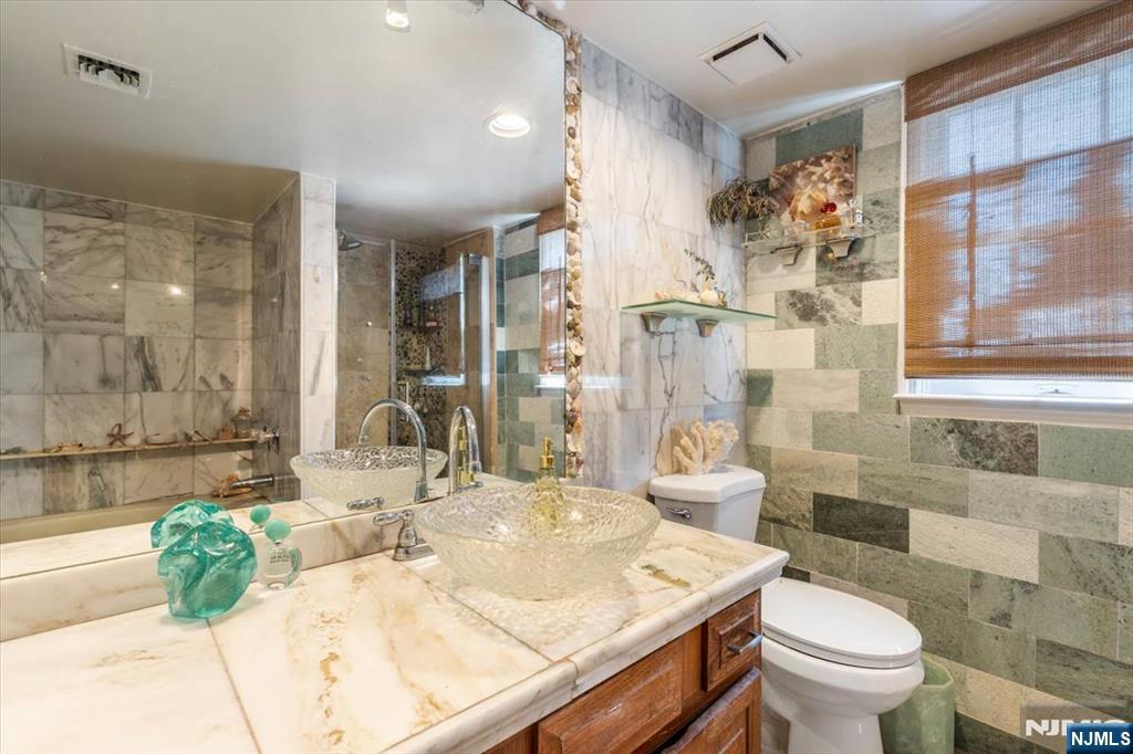 48 Quartz Lane Paterson, NJ 07501 - Photo 14 of 29 a bathroom with a granite countertop sink a toilet and shower