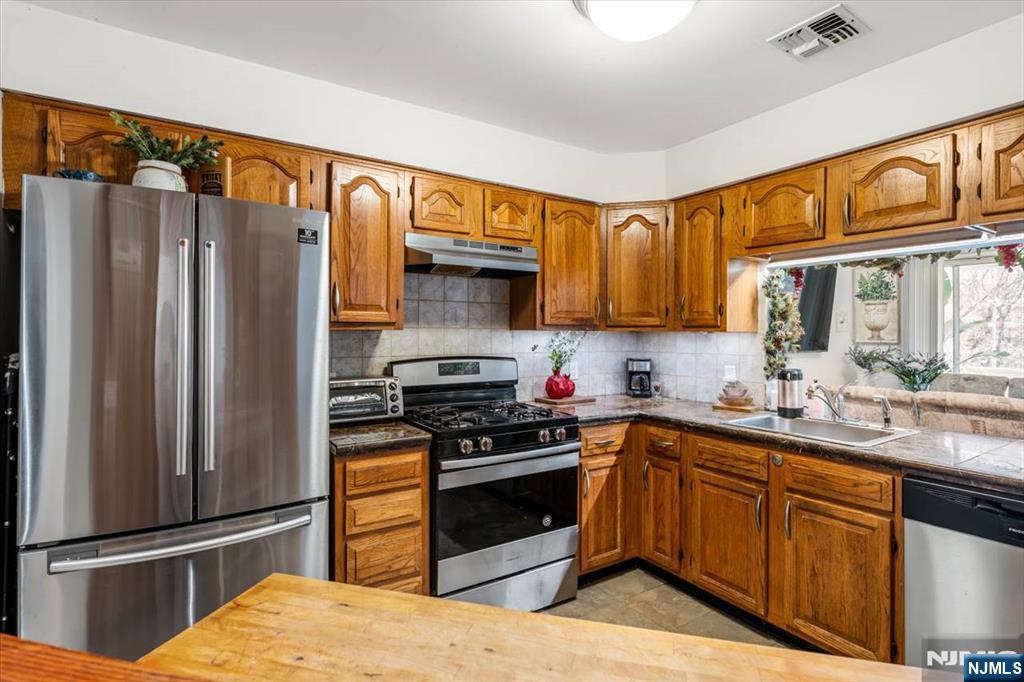 48 Quartz Lane Paterson, NJ 07501 - Photo 2 of 29 a kitchen with stainless steel appliances granite countertop a refrigerator stove and sink