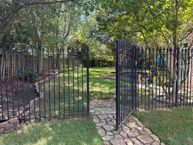 a view of a yard with a fountain and a large tree