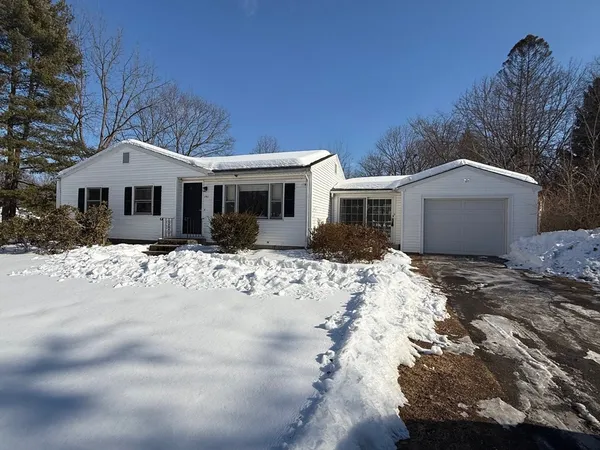 a front view of a house with a yard covered in snow