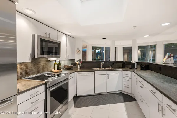 a kitchen with granite countertop a sink stove and cabinets