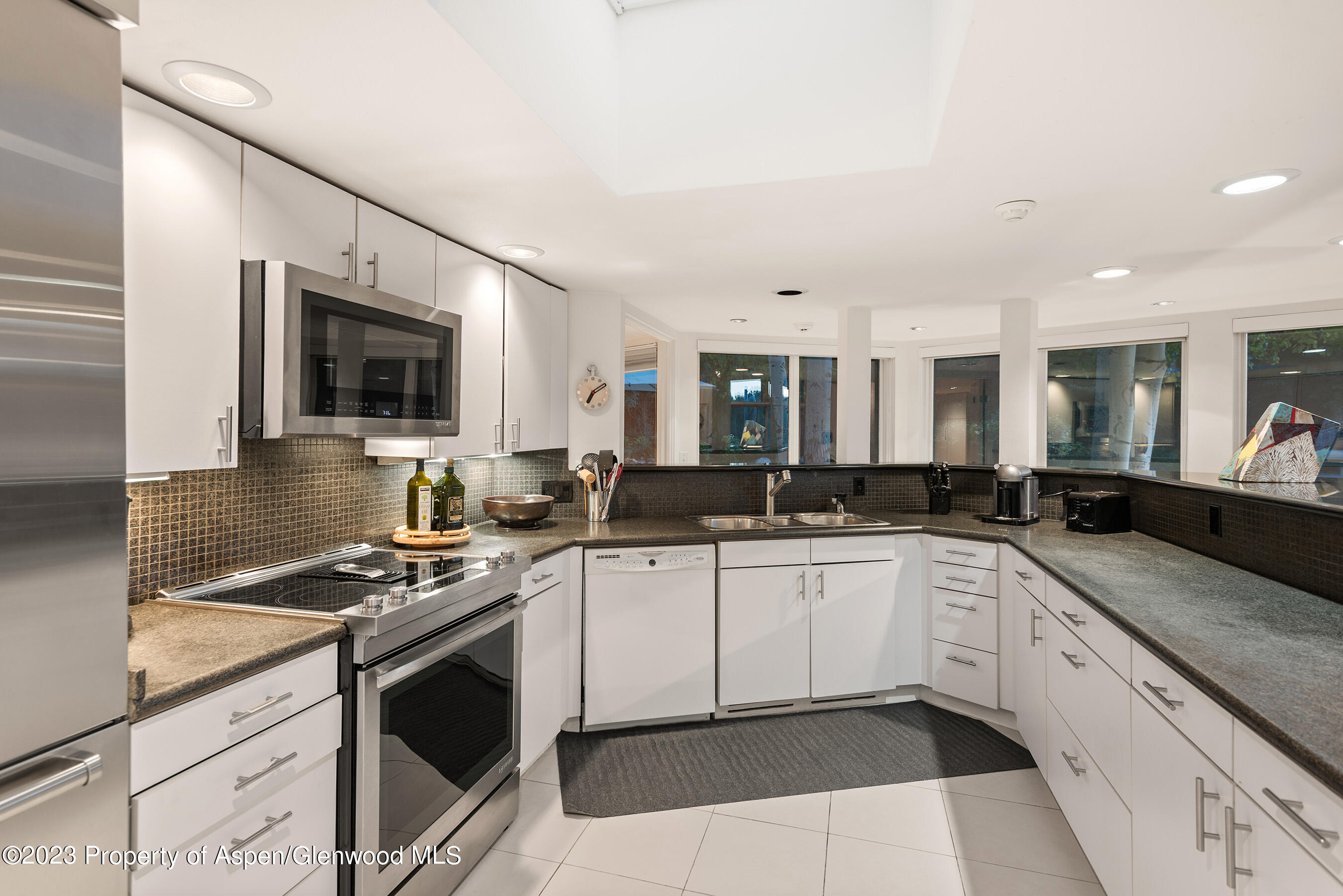 695 Meadows Road Aspen, CO 81611 - Photo 16 of 18 a kitchen with granite countertop a sink stove and cabinets