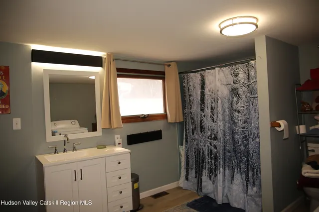 a bathroom with a double vanity sink toilet and a mirror
