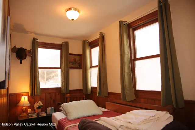 a bedroom with two beds and a dresser with mirror