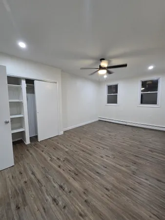 an empty room with wooden floor and window