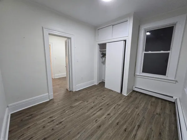 an empty room with wooden floor and closet