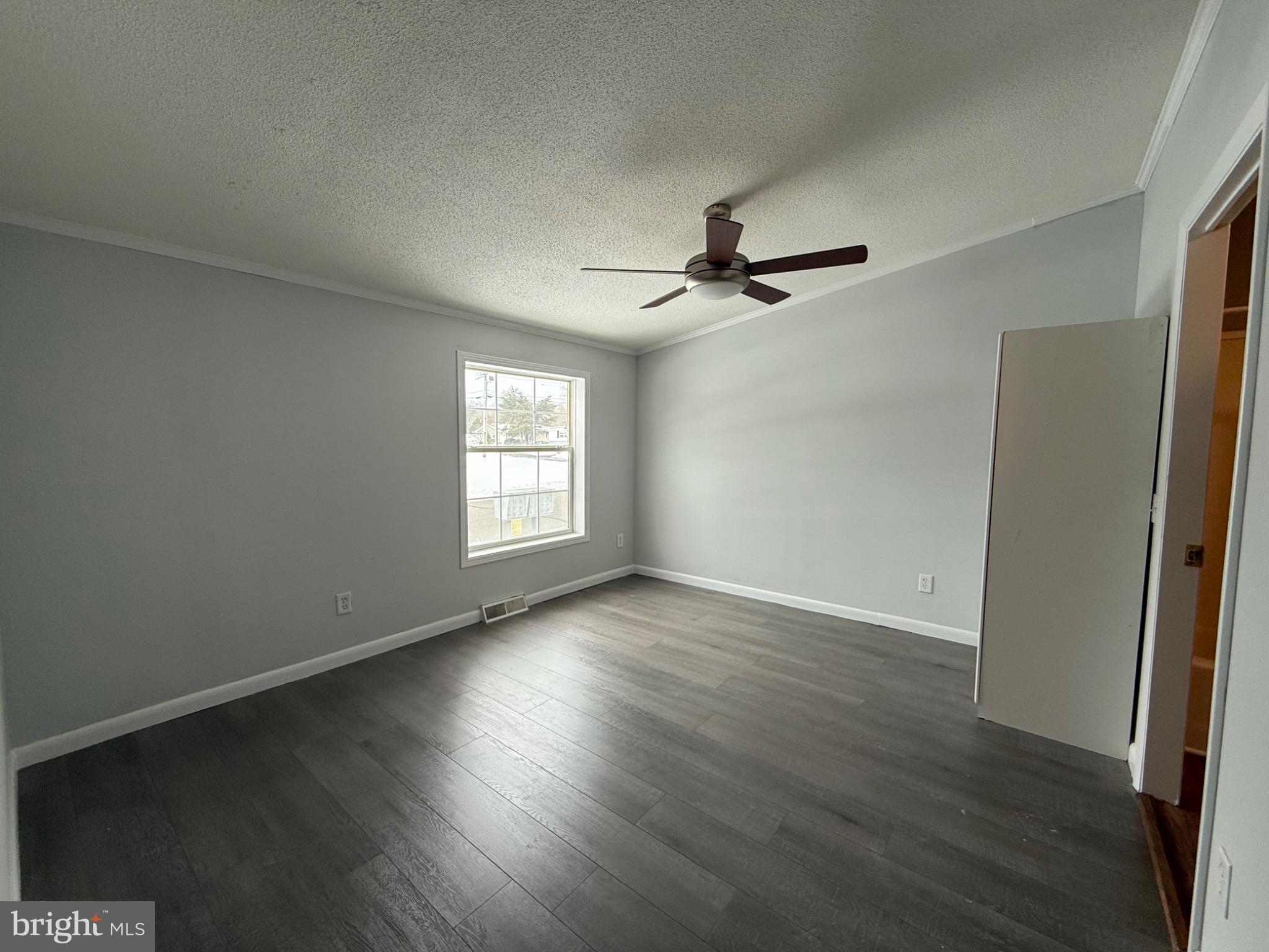 194 Jacobstown New Egypt Road, Unit 2 Wrightstown, NJ 08562 - Photo 15 of 17 an empty room with wooden floor fan and windows