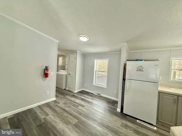 a kitchen with a sink a refrigerator and white cabinets