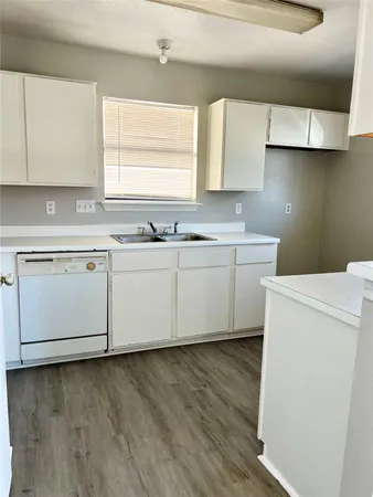 a view of cabinets a sink and wooden floor