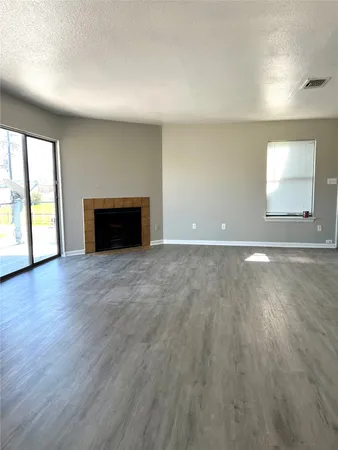 an empty room with wooden floor and fireplace