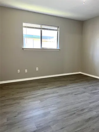 a view of a room with wooden floor and window