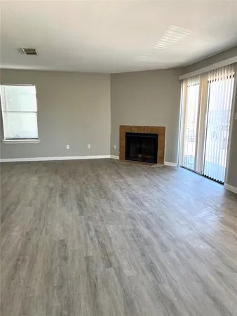 a view of empty room with wooden floor and fireplace
