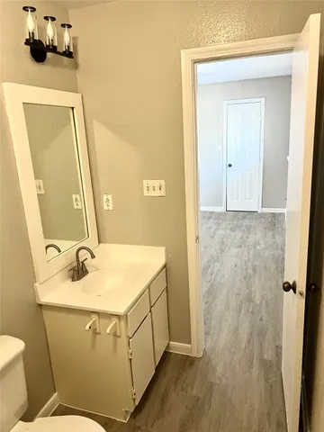 a bathroom with a sink and mirror with toilet