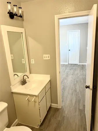 a bathroom with a sink and mirror with toilet