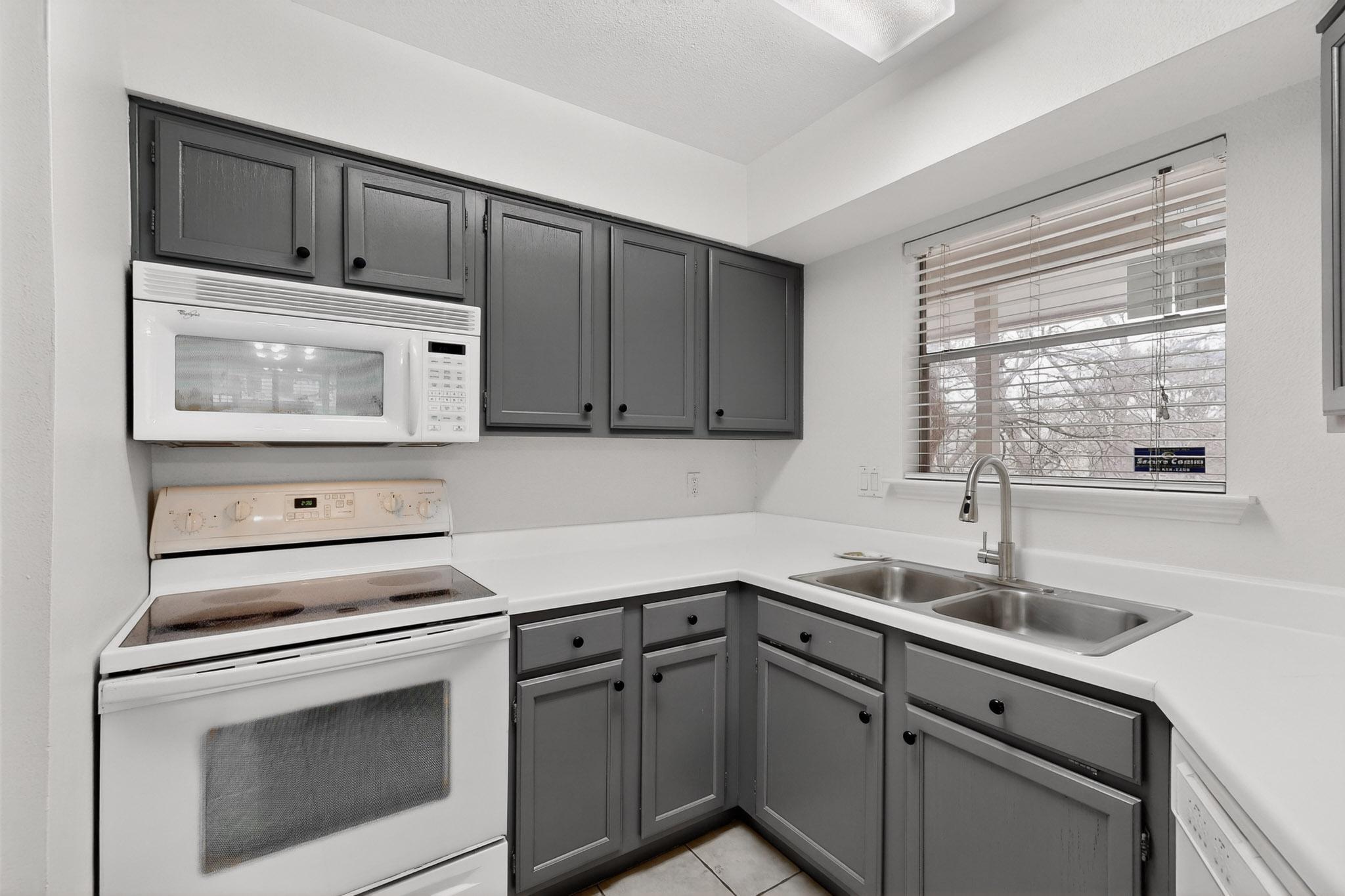 2450 Wickersham Lane, Unit 904 Austin, TX 78741 - Photo 11 of 35 a kitchen with sink cabinets and window