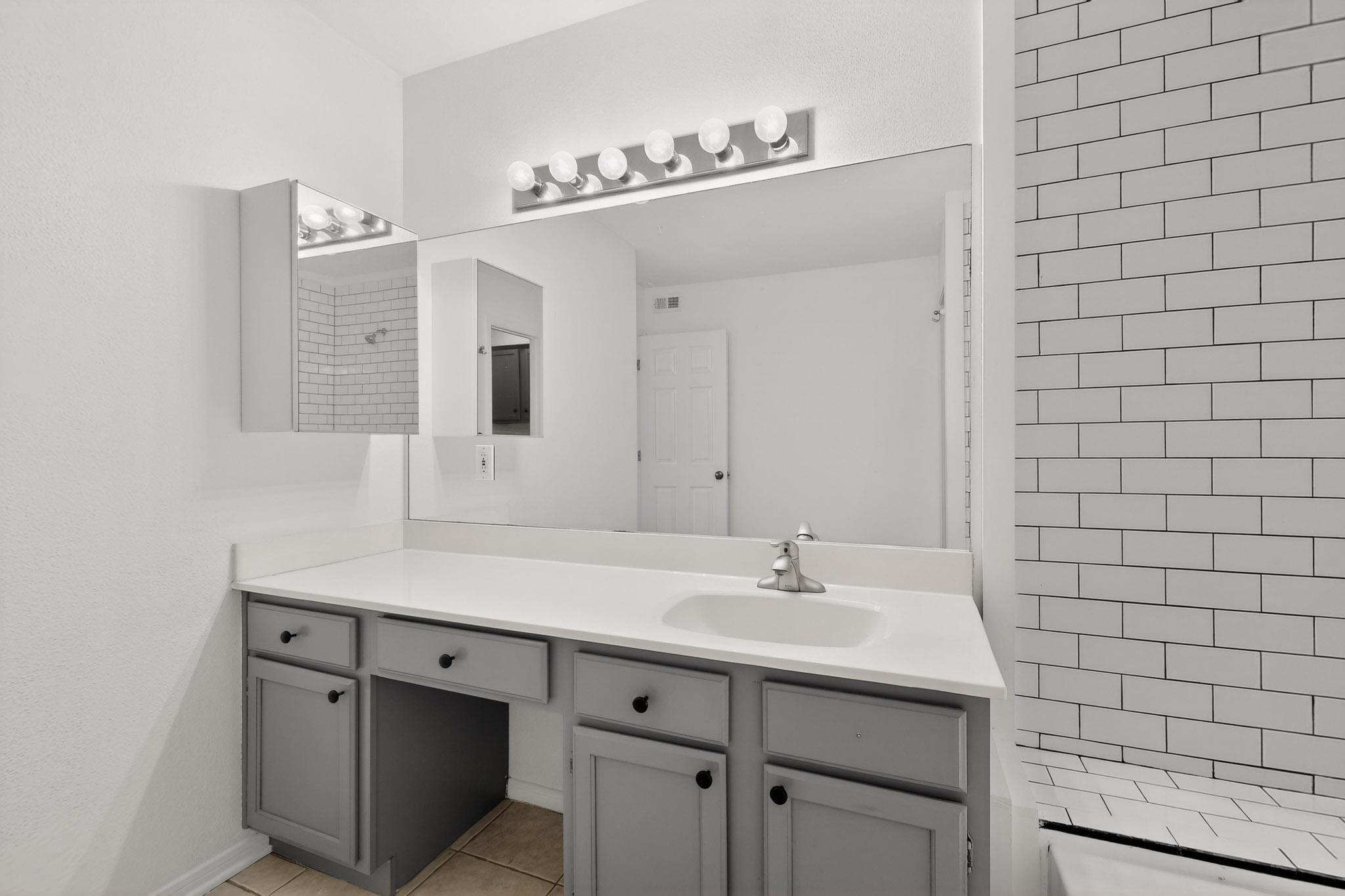 2450 Wickersham Lane, Unit 904 Austin, TX 78741 - Photo 21 of 35 a bathroom with a sink vanity and mirror